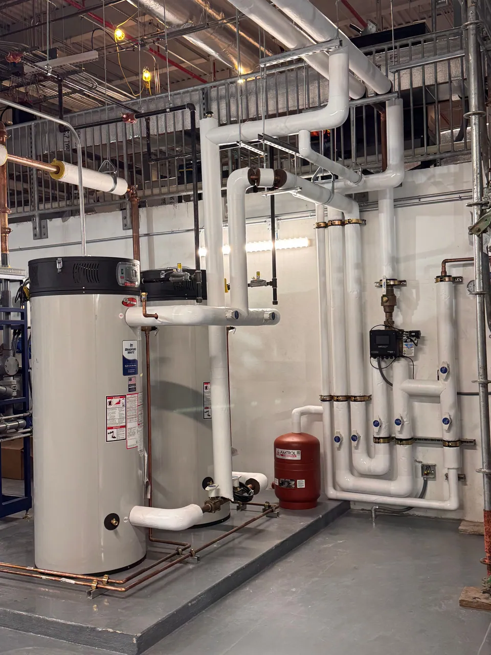 Commercial water heater with insulated piping and an expansion tank in a clean mechanical room